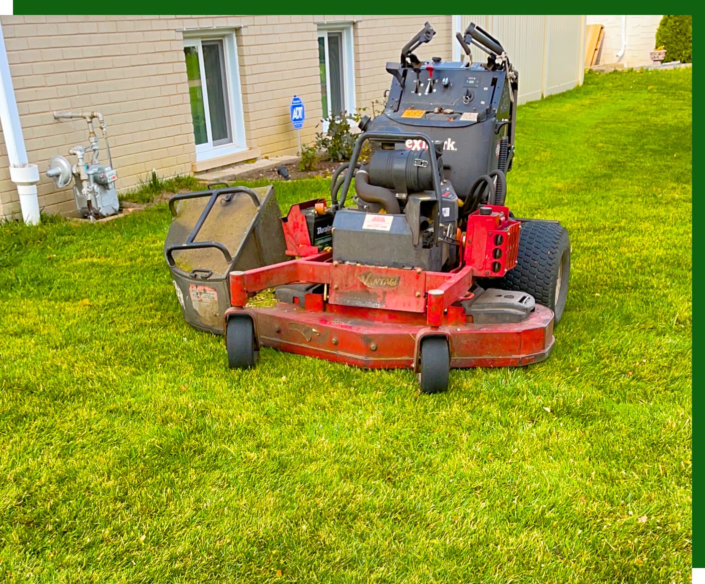 a red lawnmower parked after finishing a lawn mowing job for one of our clients